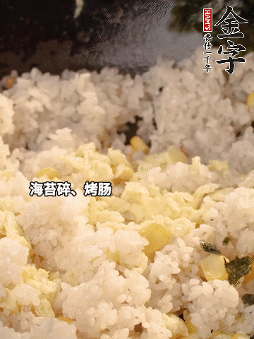 剩米飯下鍋炒散，依次下玉米粒、雞蛋、烤腸、海苔碎翻炒均勻。
