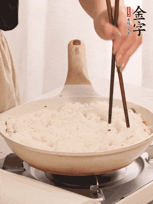 把瀝干水分的米飯均勻鋪在上面，筷子戳幾個洞，以便透氣，轉(zhuǎn)小火蓋上蓋子燜至水分收干，大概10分鐘。